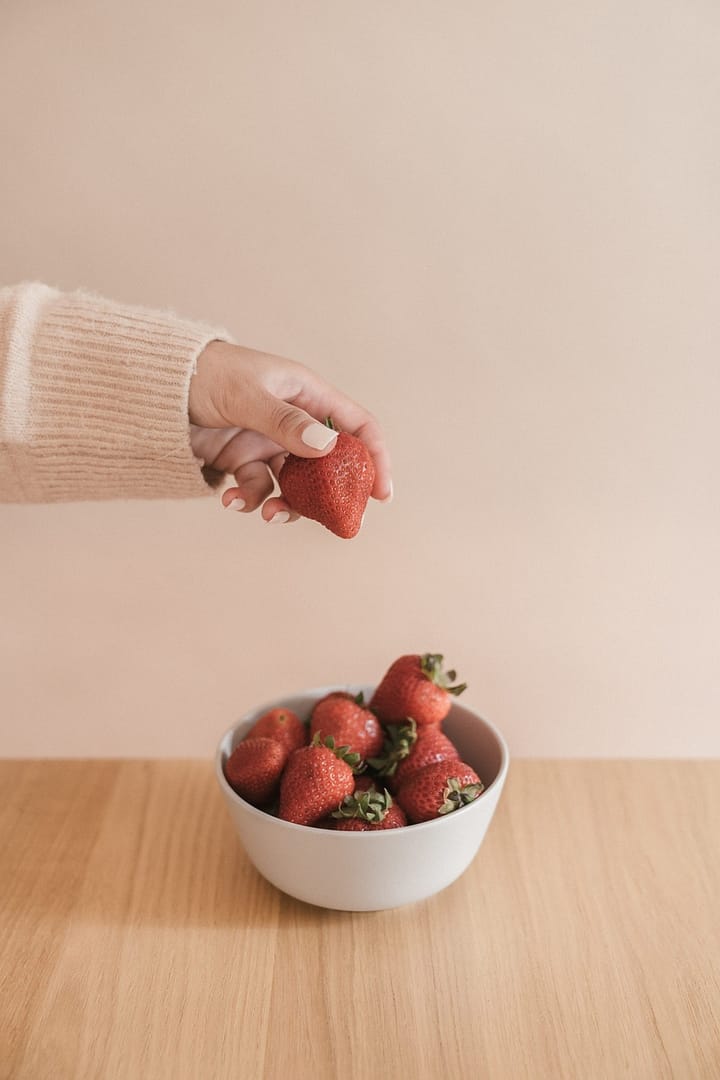 Female eating strawberries, representing dieting and eating disorders.